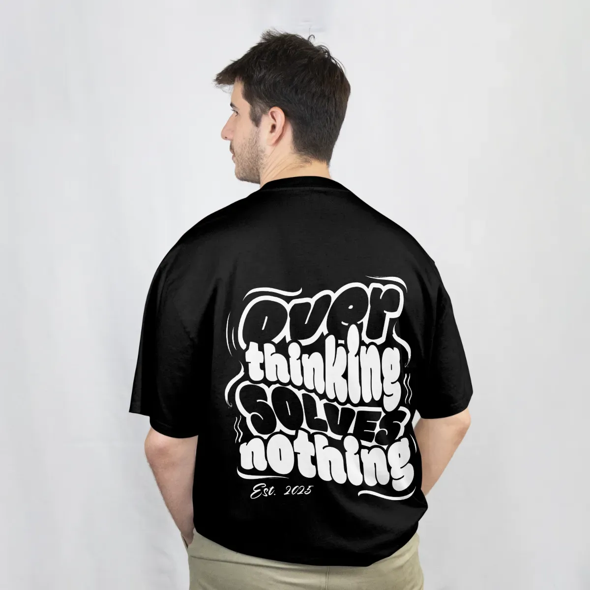 Playera negra, vista de espalda con la frase «Overthinking solves nothing» en letras blancas