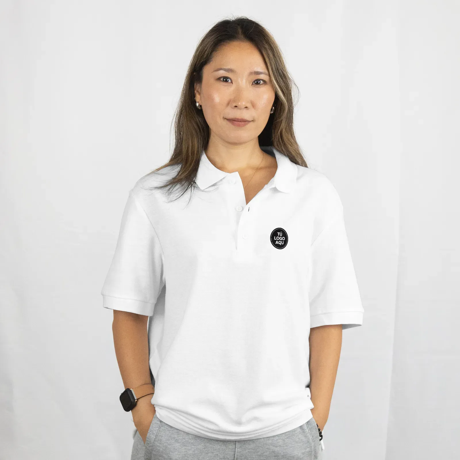 Polo blanco con el logotipo de la empresa en el pecho, modelo mujer